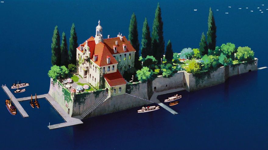 An aerial shot of a grand manor on a secluded island.